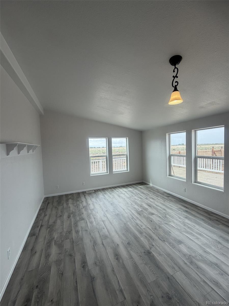 5511 Ridgetop Court Alamosa, CO 81101 - Photo 4 of 10 wooden floor in an empty room with a window
