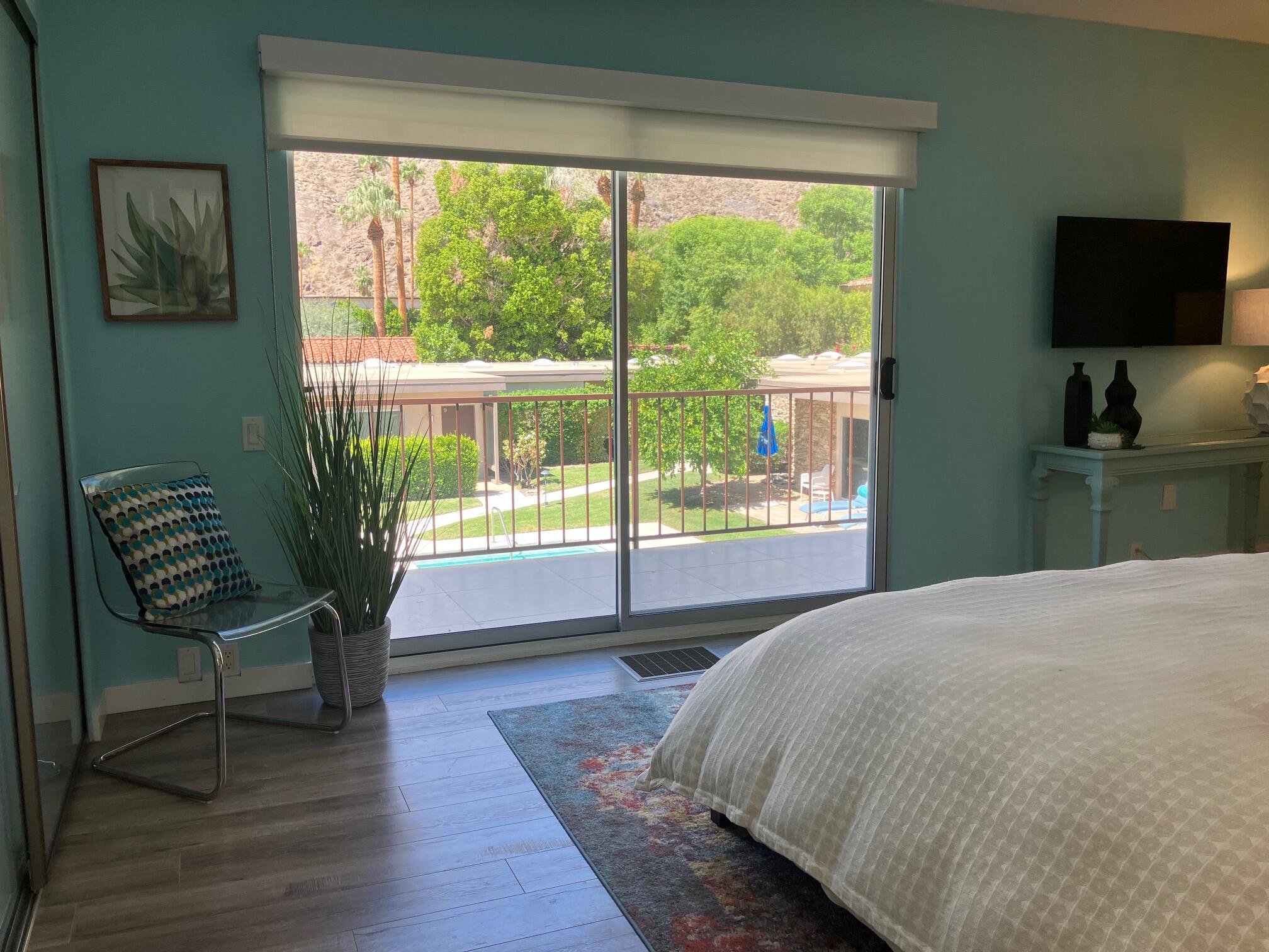 500 West Arenas Road, Unit 2 Palm Springs, CA 92262 - Photo 25 of 36 a spacious bedroom with a bed and a chair