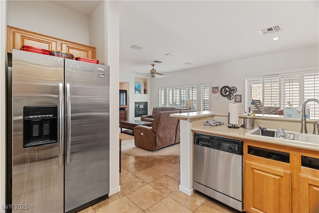 2078 Willow Bay Road Laughlin, NV 89029 - Photo 98 of 99 Kitchen featuring stainless steel appliances, light countertops, open floor plan, a glass covered fireplace, and light tile patterned floors