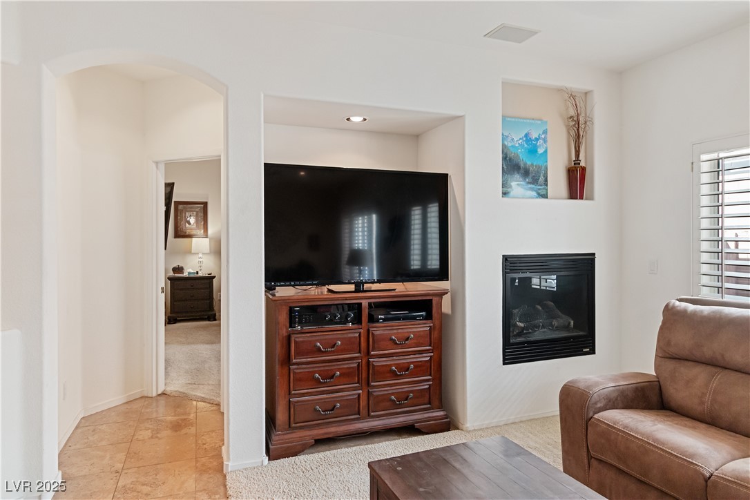 2078 Willow Bay Road Laughlin, NV 89029 - Photo 19 of 99 Family Room featuring light colored carpet, light tile patterned floors, and arched walkways