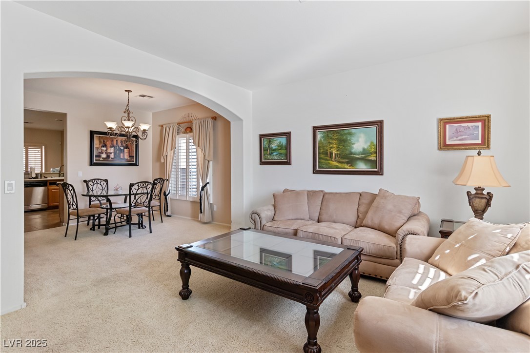 2078 Willow Bay Road Laughlin, NV 89029 - Photo 10 of 99 Carpeted living room with arched walkways and a chandelier