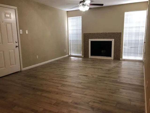 a view of empty room with wooden floor and fireplace