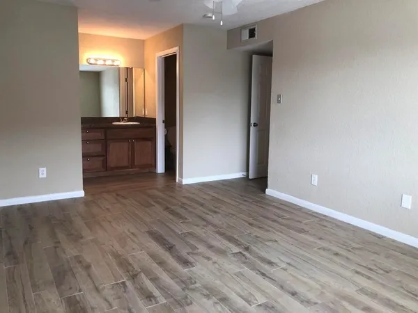 an empty room with wooden floor and cabinet