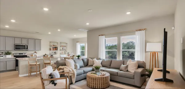a living room with furniture flat screen tv and a large window