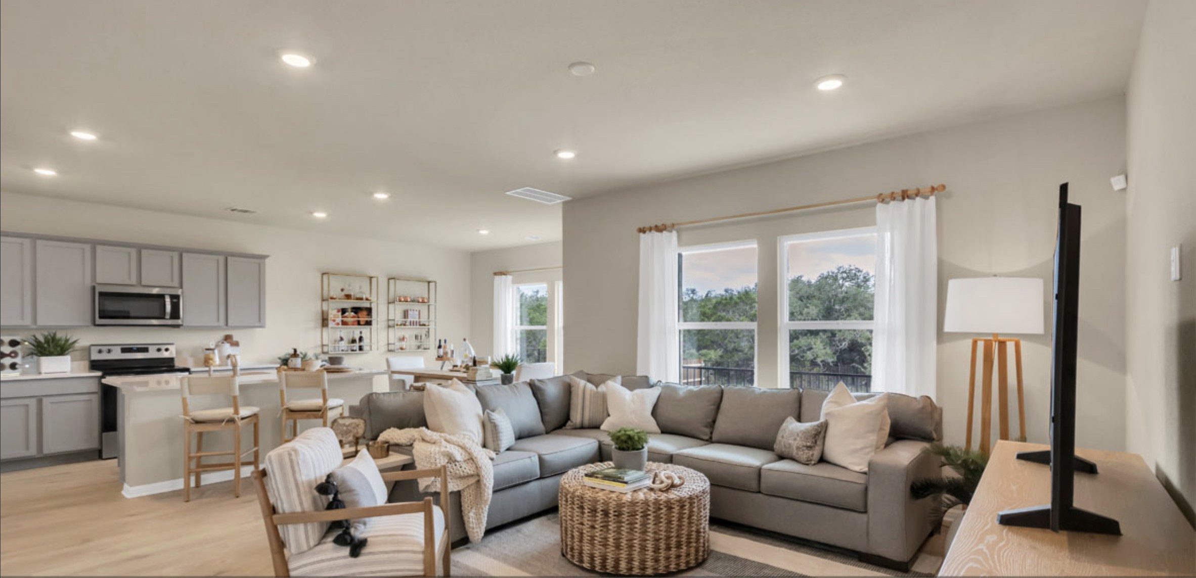 a living room with furniture flat screen tv and a large window