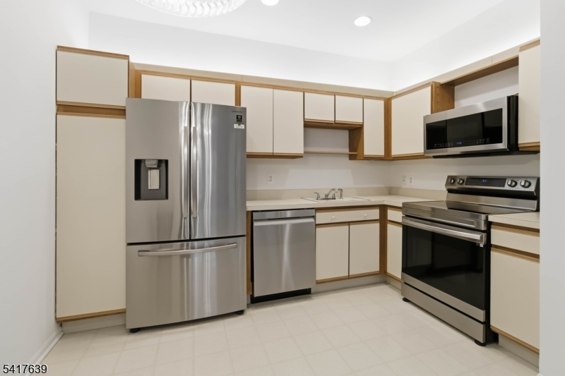 5301 Richmond Road, Unit 301 West Milford, NJ 07480 - Photo 5 of 33 a kitchen with stainless steel appliances granite countertop a refrigerator stove a sink and a microwave