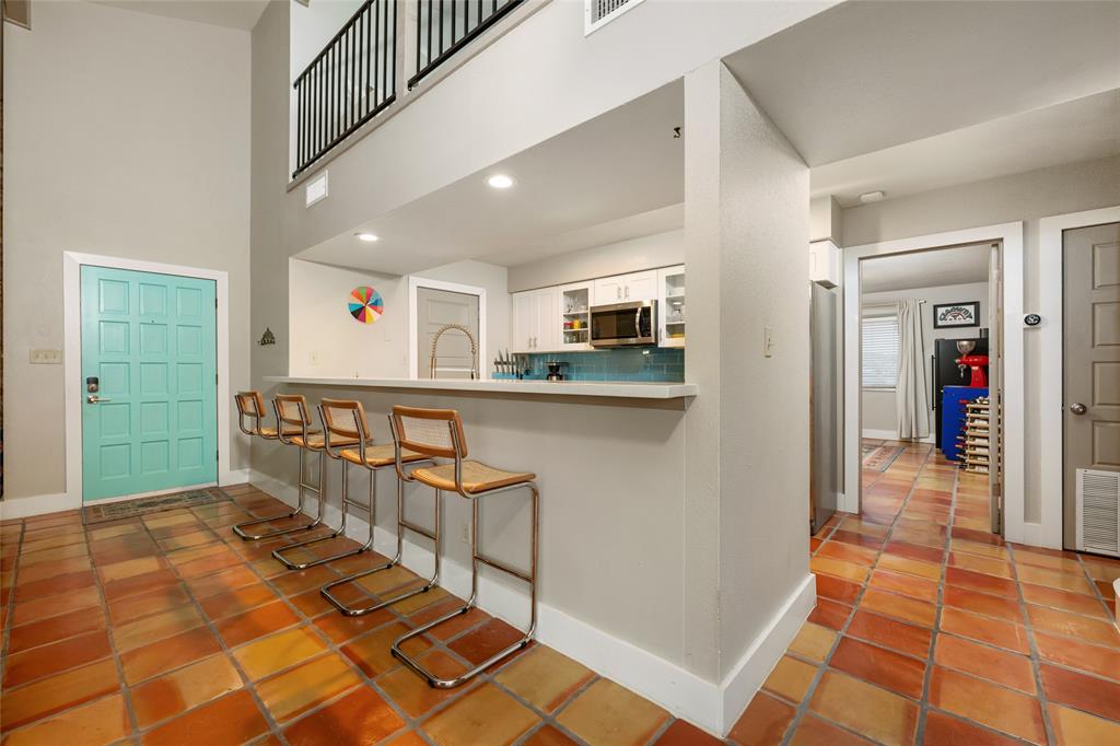 2210 Red Fox Road Austin, TX 78734 - Photo 12 of 40 A spacious entry with a vibrant turquoise door introduces a kitchen bar and soaring ceilings.