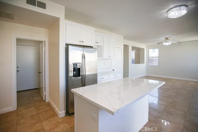 a kitchen with white cabinets appliances and window