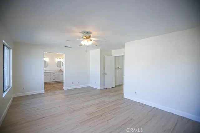 a bathroom with double vanity sink a two mirror a window a bathtub and vanity