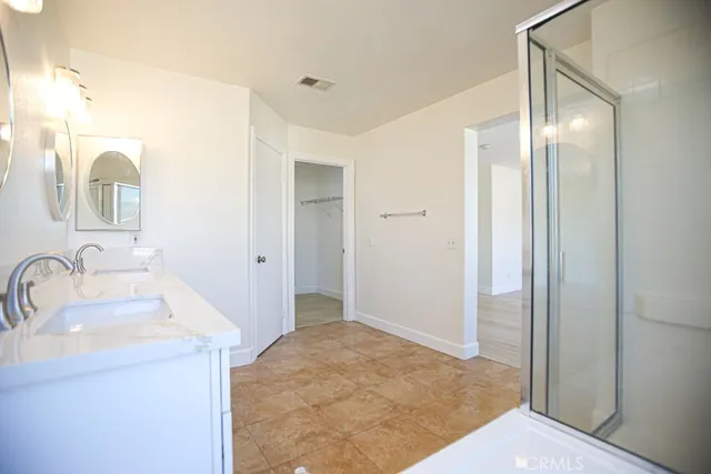 a spacious bathroom with a double vanity sink and a mirror