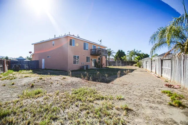 a view of an house with backyard space and balcony