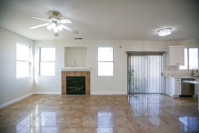 a view of an empty room with a fireplace and window