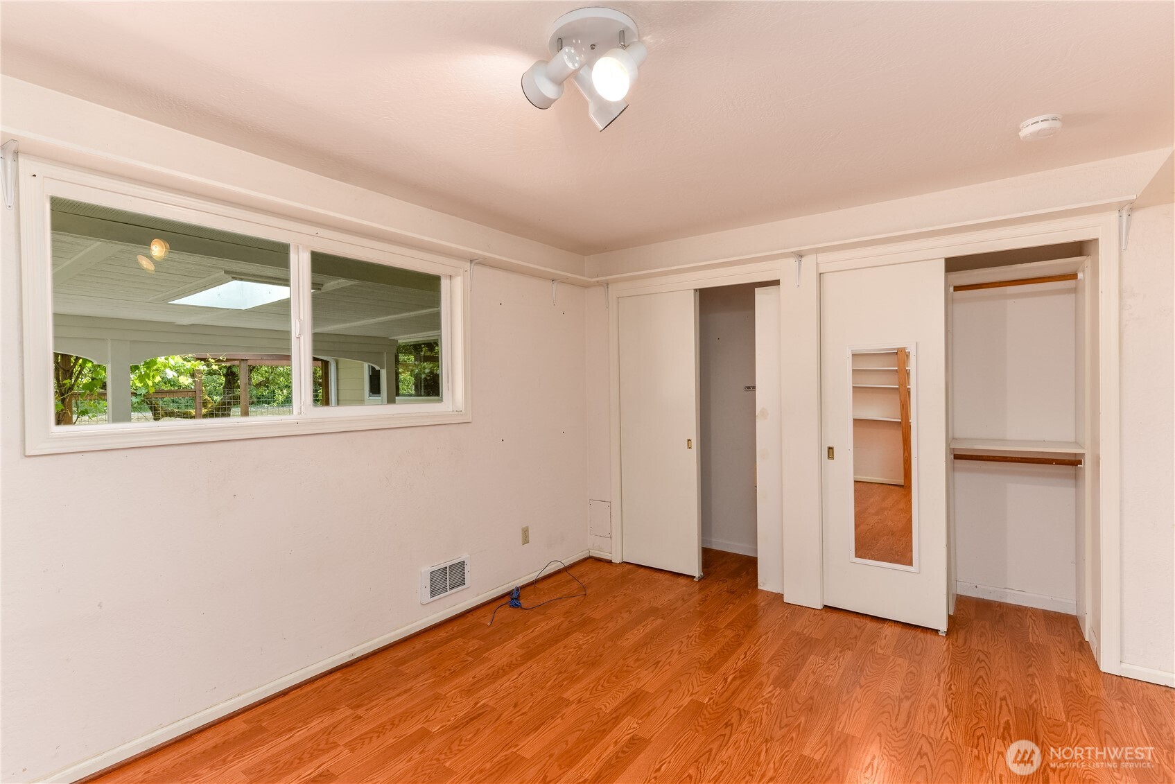4109 South Reddick Road Port Angeles, WA 98363 - Photo 18 of 38 a view of an empty room with a window and wooden floor