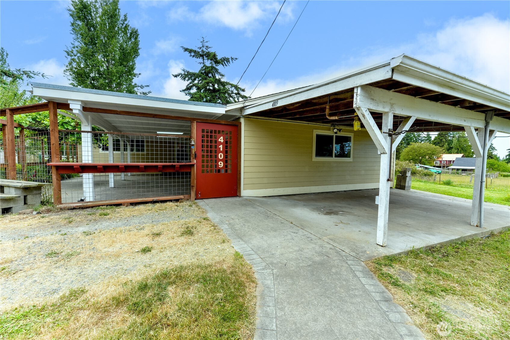 4109 South Reddick Road Port Angeles, WA 98363 - Photo 25 of 38 a view of a house with a garage and potted plants