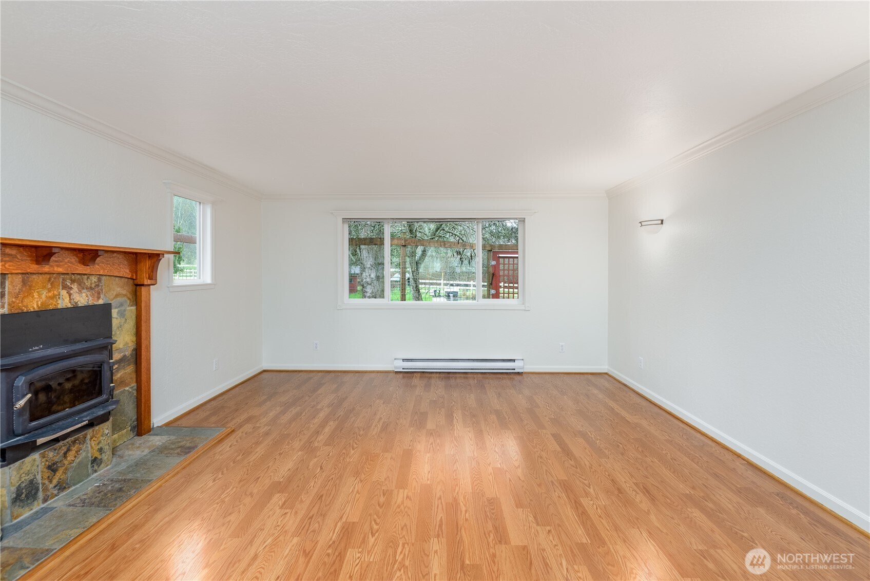 4109 South Reddick Road Port Angeles, WA 98363 - Photo 4 of 38 an empty room with windows fireplace and wooden floor