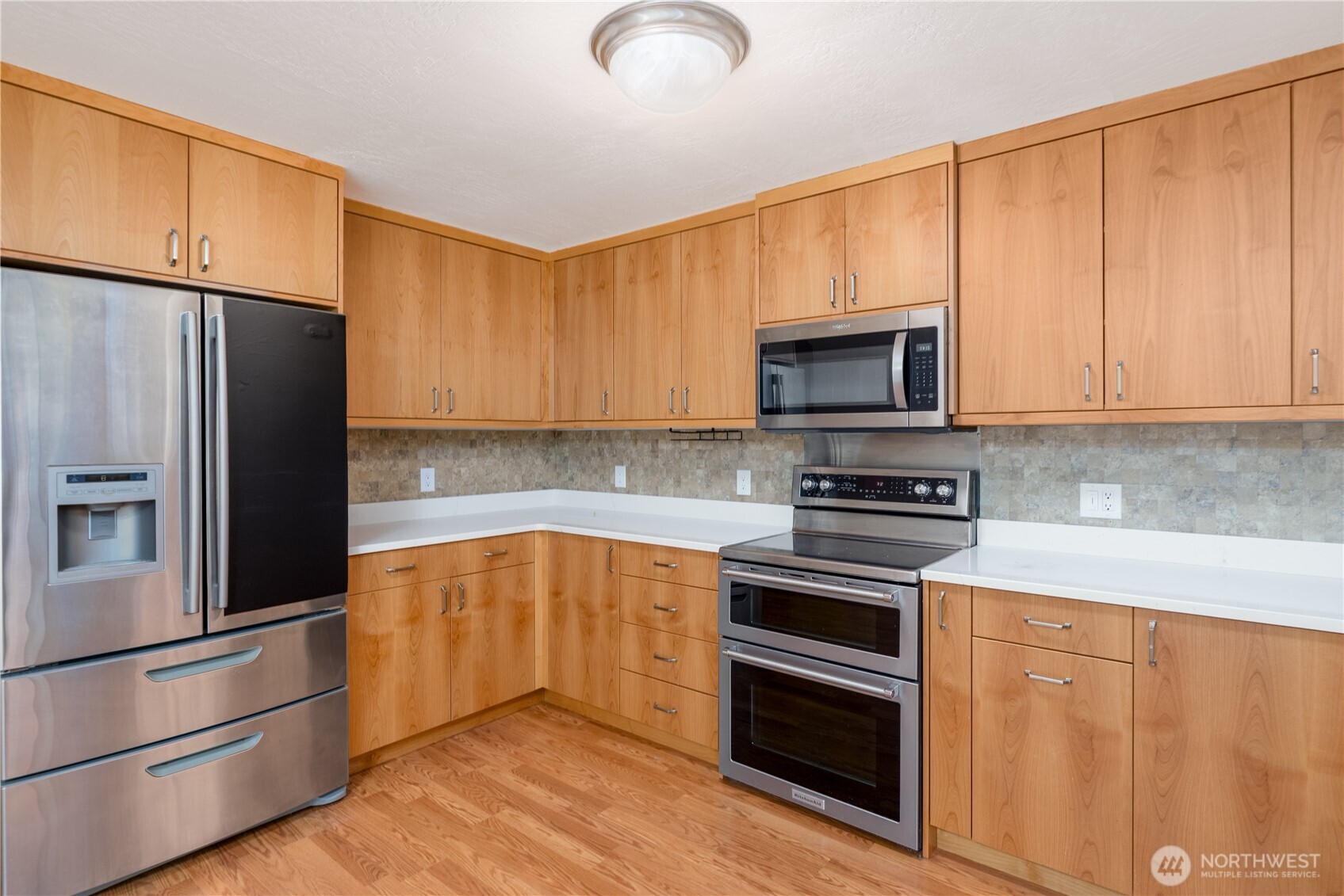 4109 South Reddick Road Port Angeles, WA 98363 - Photo 7 of 38 a kitchen with granite countertop a refrigerator stove and microwave