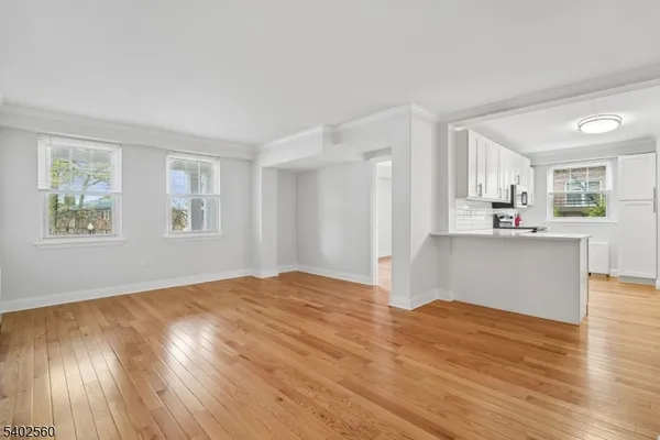a view of a kitchen with wooden floor and a window