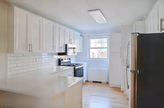 a kitchen with a sink a refrigerator and cabinets