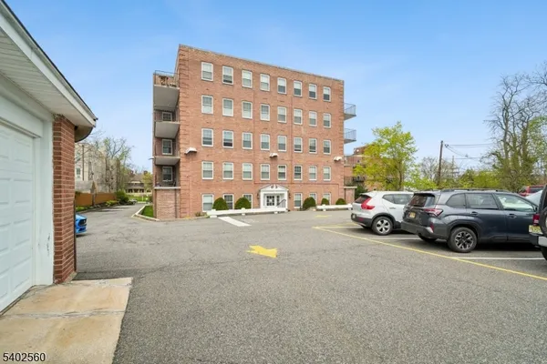 a view of building with cars parked in front of it