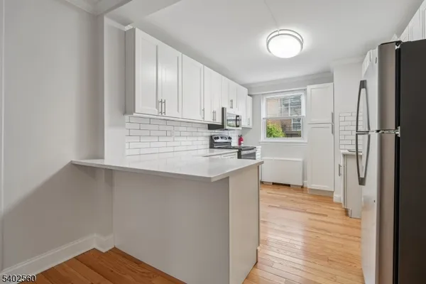 a kitchen with white cabinets stainless steel appliances and sink