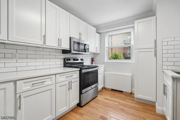 a kitchen with white cabinets and stainless steel appliances