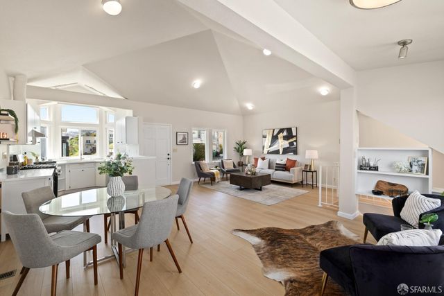a living room with furniture and a dining table