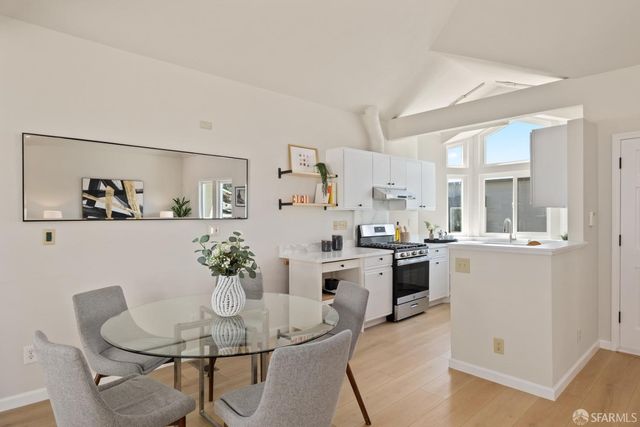 a dining room with kitchen island stainless steel appliances a table and chairs