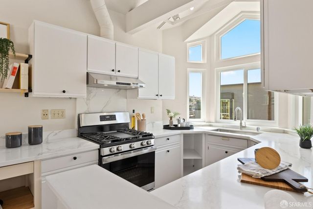 a kitchen with granite countertop a stove sink and cabinets