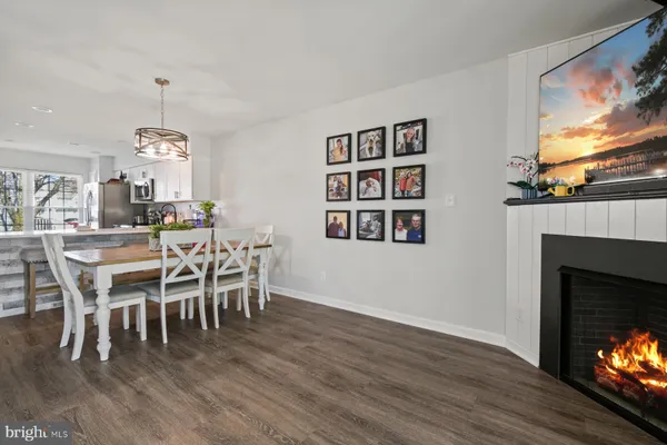 a dining room with furniture wooden floor a fireplace and a chandelier