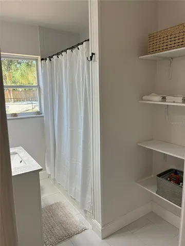 a bathroom with a shower curtain and a window