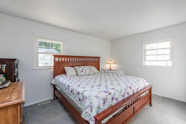 a bedroom with a bed and a dresser with mirror