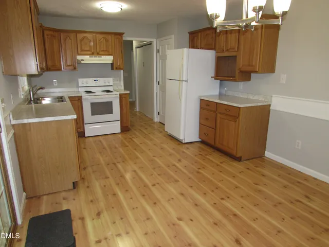 a kitchen with wooden cabinets and white appliances