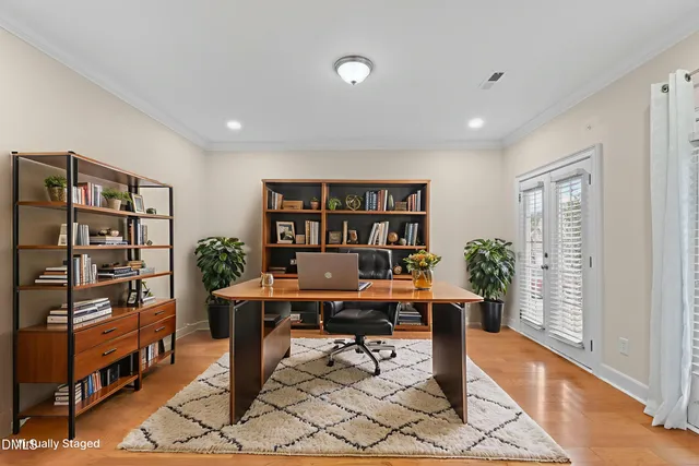 an empty room with wooden floor fireplace and windows