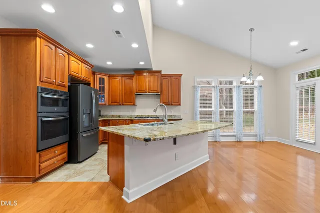 a spacious bedroom with a bed a couch and a potted plant on the dresser