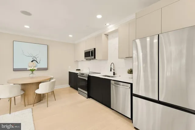 a living room with stainless steel appliances kitchen island granite countertop furniture a refrigerator a sink and white cabinets