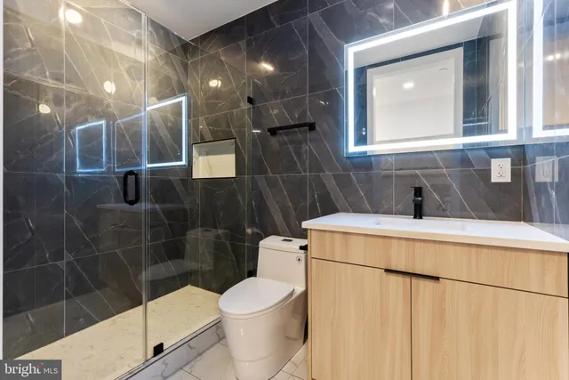 a bathroom with a toilet a sink and mirror