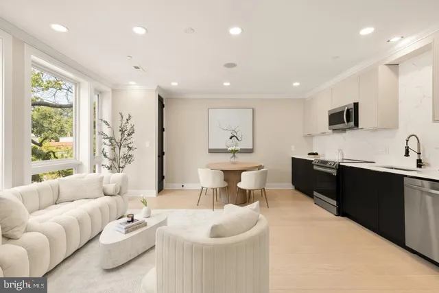 a living room with furniture a window and a flat screen tv