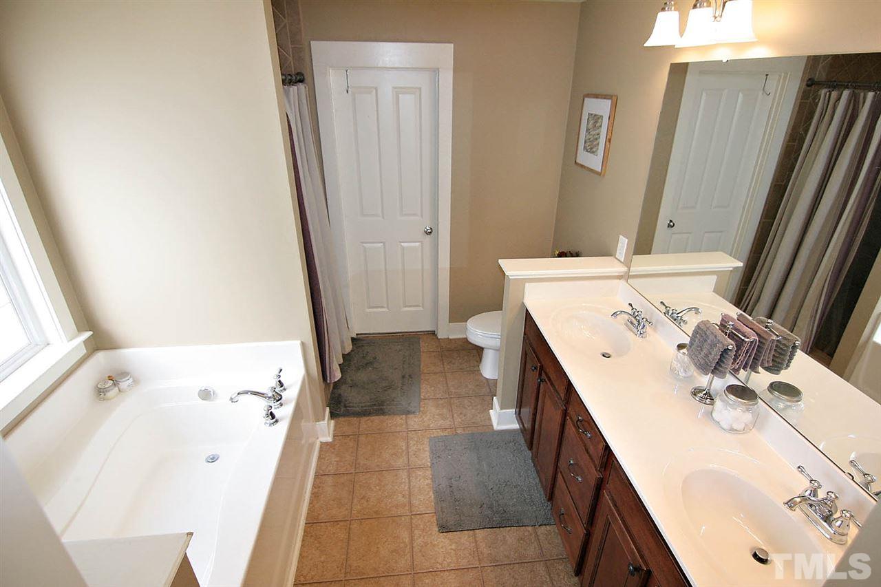 2248 Dunlin Lane Raleigh, NC 27614 - Photo 15 of 24 a bathroom with a sink a mirror and a bathtub