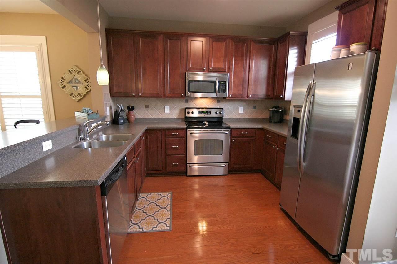 2248 Dunlin Lane Raleigh, NC 27614 - Photo 9 of 24 a kitchen with stainless steel appliances granite countertop a sink stove refrigerator and cabinets