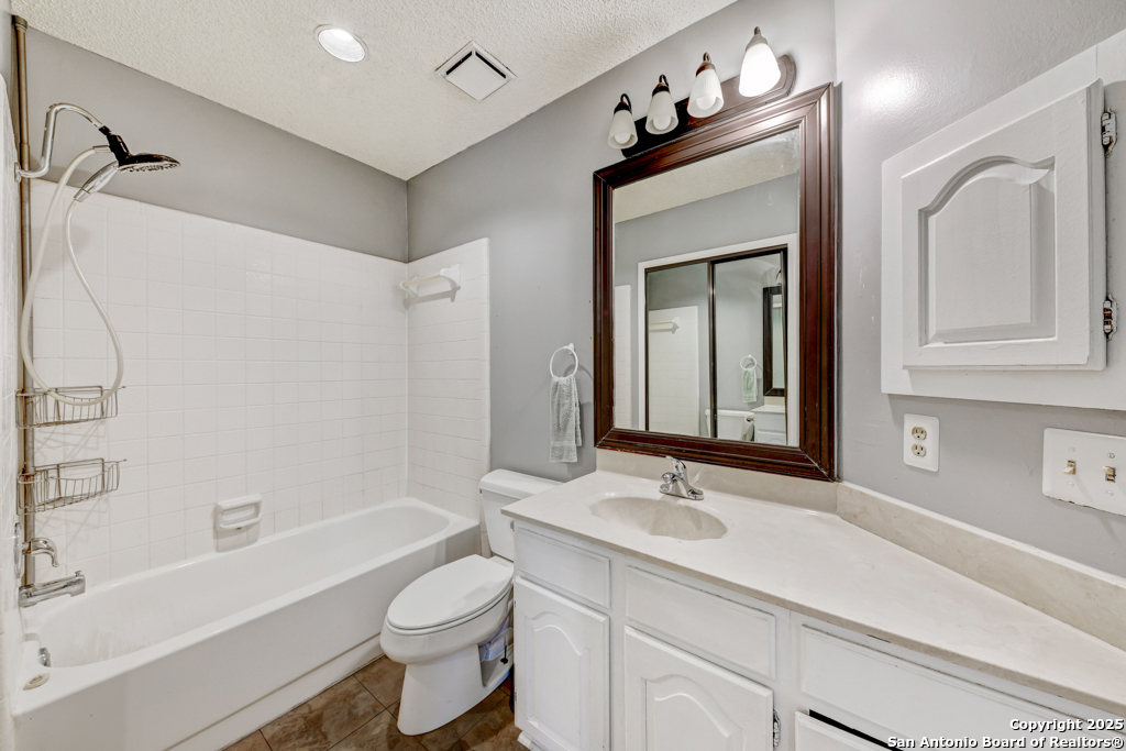 15010 Spring Shower San Antonio, TX 78247 - Photo 22 of 27 a bathroom with a toilet a sink a tub and a mirror