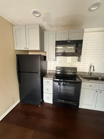a kitchen with a refrigerator and a stove