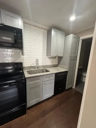 a kitchen with stainless steel appliances a stove sink and microwave