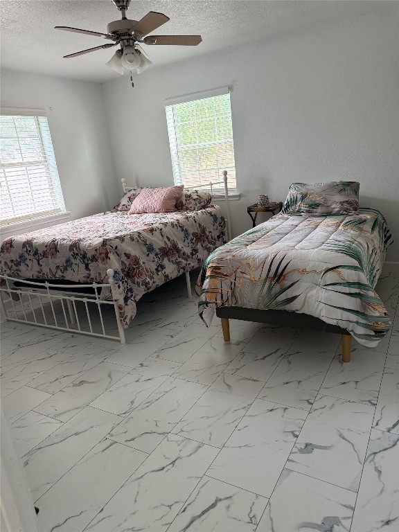968 Red Town Road Elgin, TX 78621 - Photo 12 of 36 Bedroom with multiple windows, a textured ceiling, and marble finish flooring