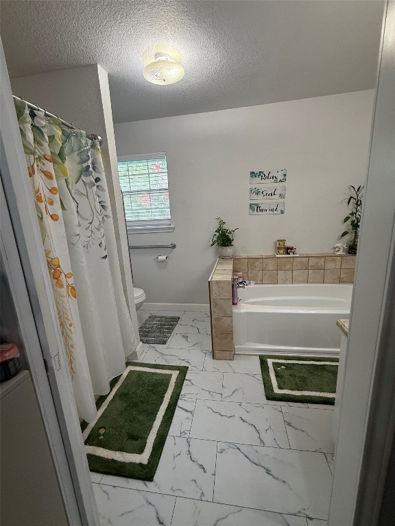 968 Red Town Road Elgin, TX 78621 - Photo 17 of 36 Full bathroom featuring marble look tiles, a garden tub, and a textured ceiling