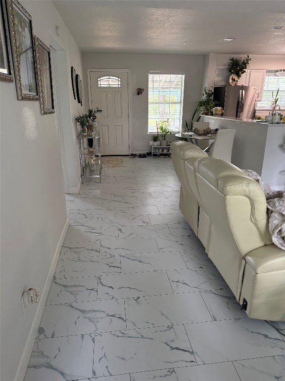 968 Red Town Road Elgin, TX 78621 - Photo 9 of 36 Living room featuring light marble finish flooring and a textured ceiling