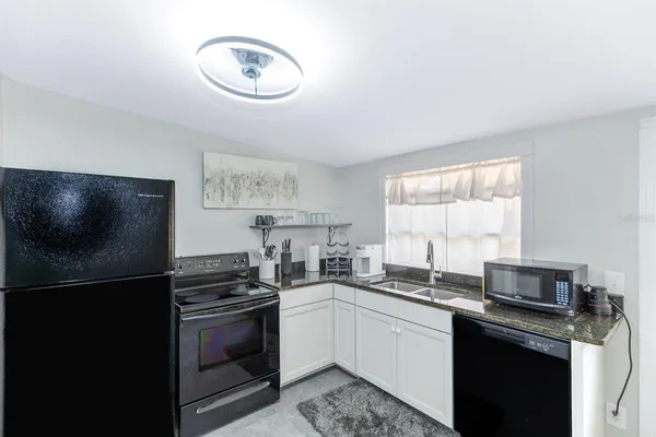 a kitchen with a sink cabinets stainless steel appliances and a window