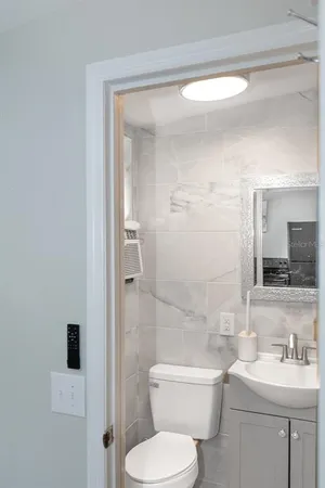 a bathroom with a toilet sink a mirror and shower