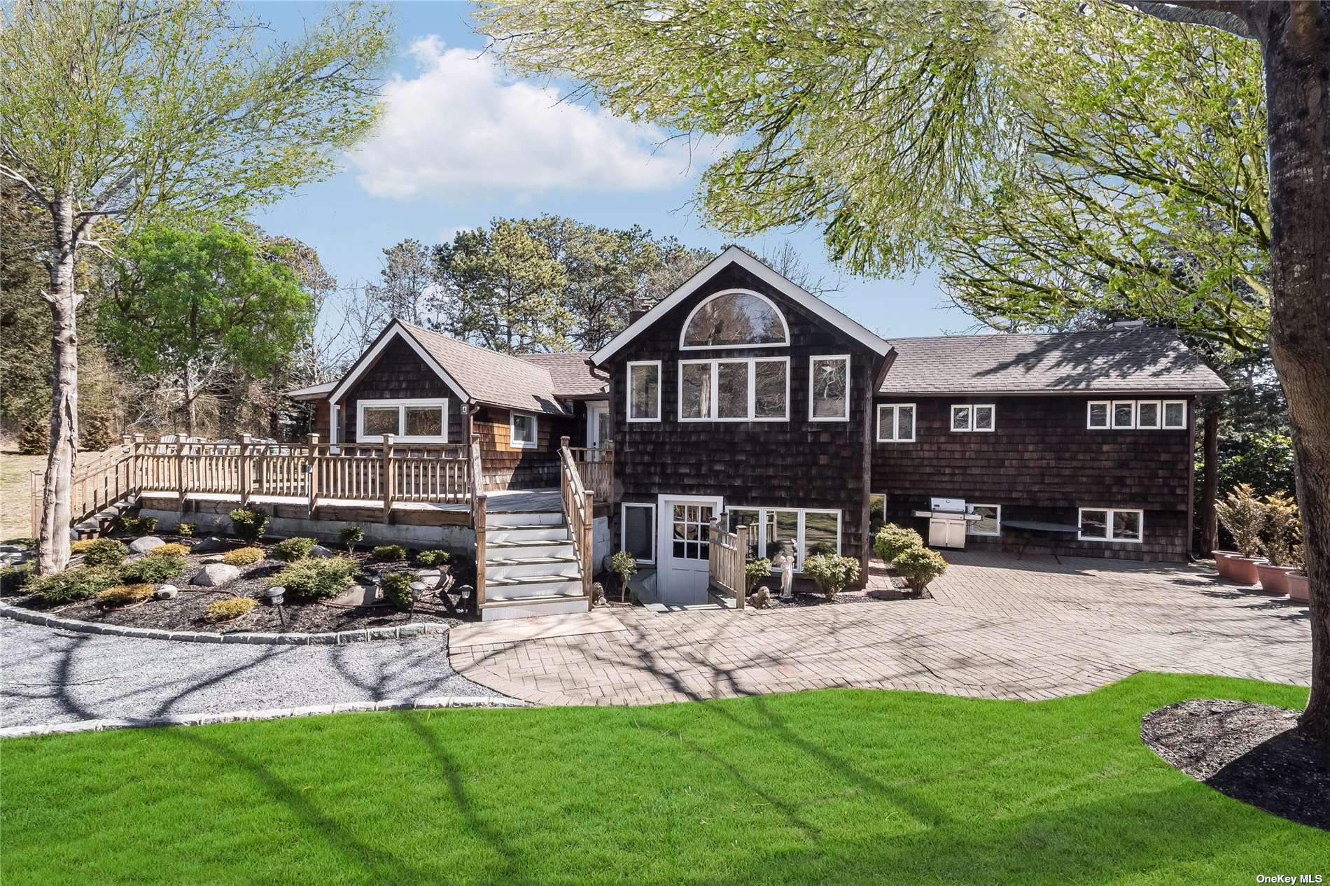 a front view of a house with a yard and trees