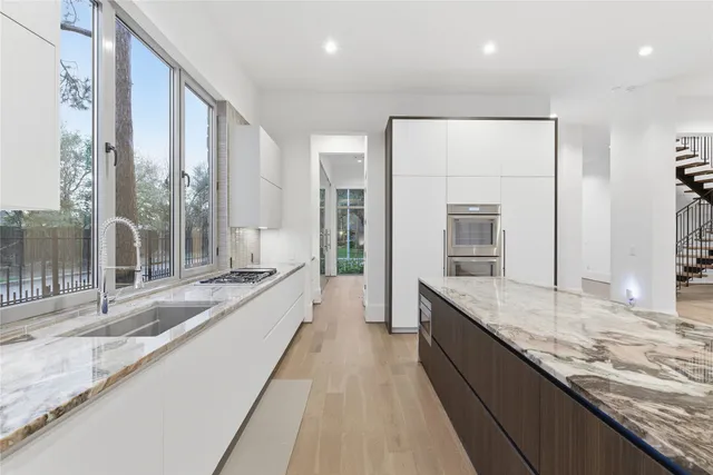 a large kitchen with granite countertop a large counter top and sink