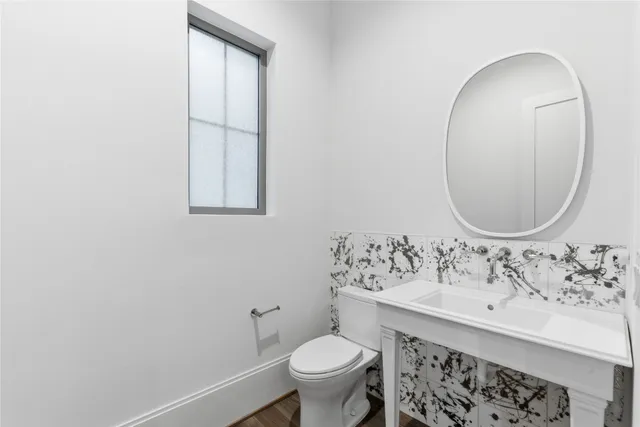 a bathroom with a sink toilet and a mirror